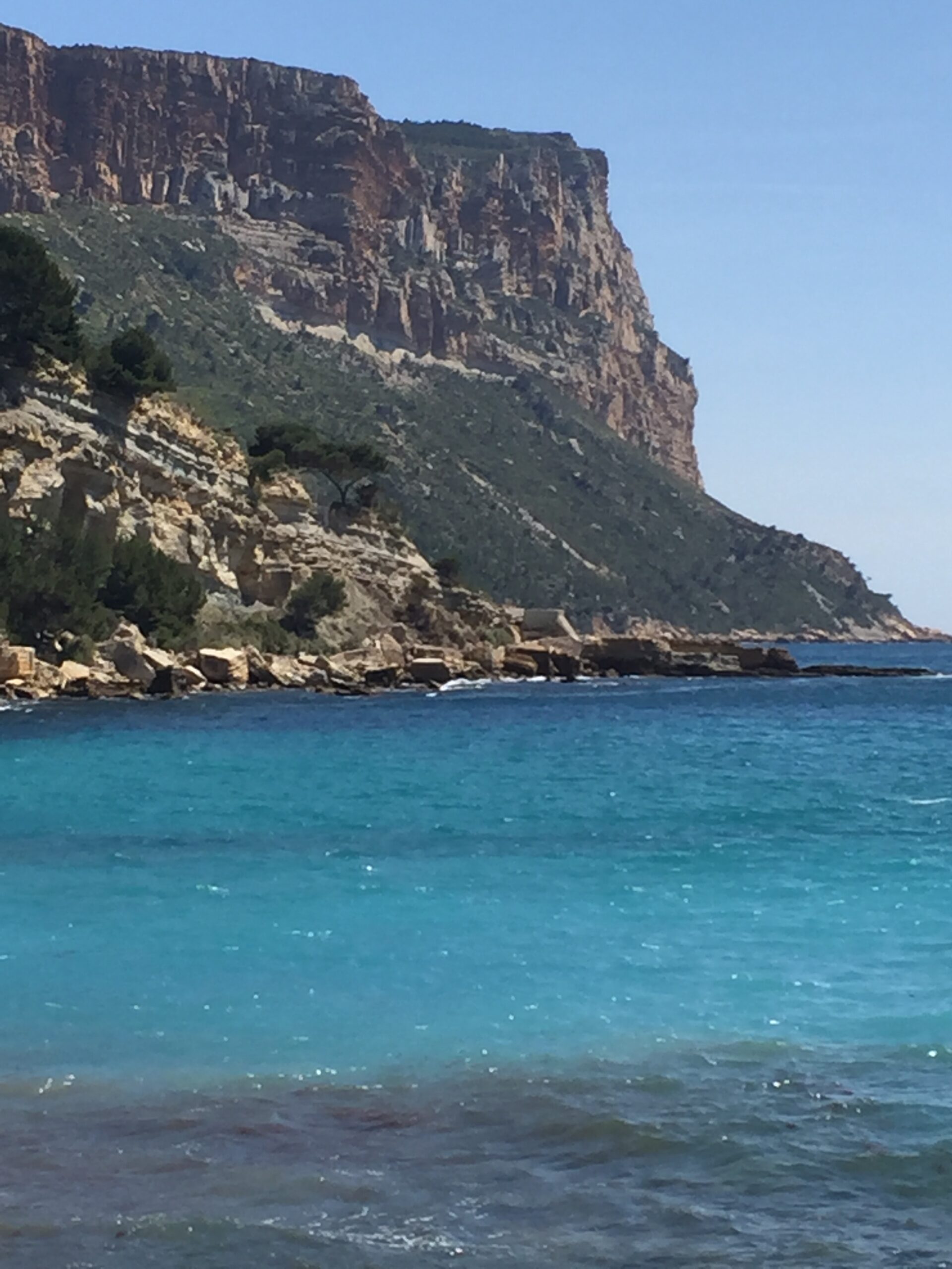 Sparkling blue green Mediterranean with rough waves crushing rocky cliffs in Cassis Provence, France