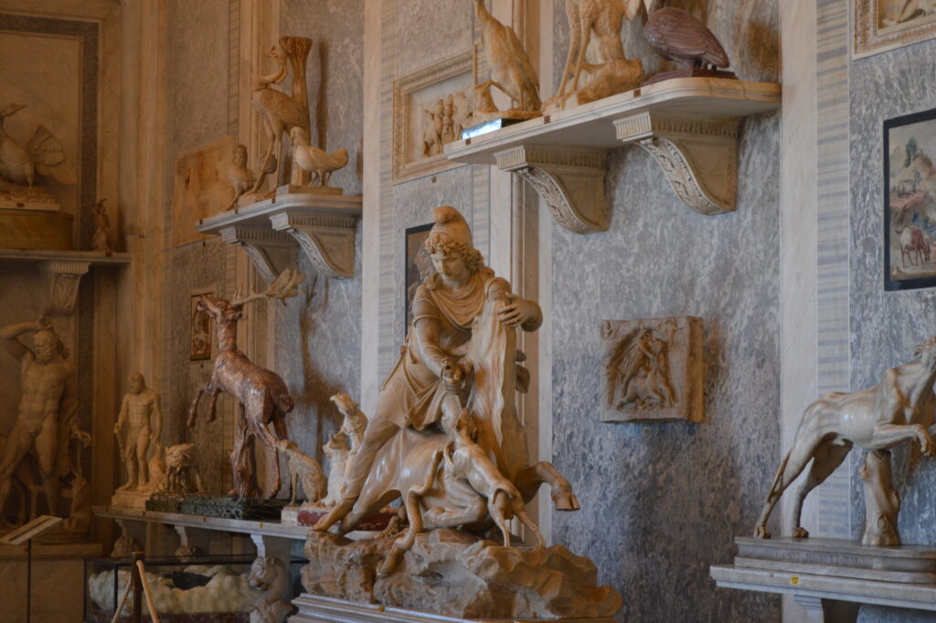 Clay colored intricately carved marble statures of animals and man on display at the Vatican Museum Rome Italy